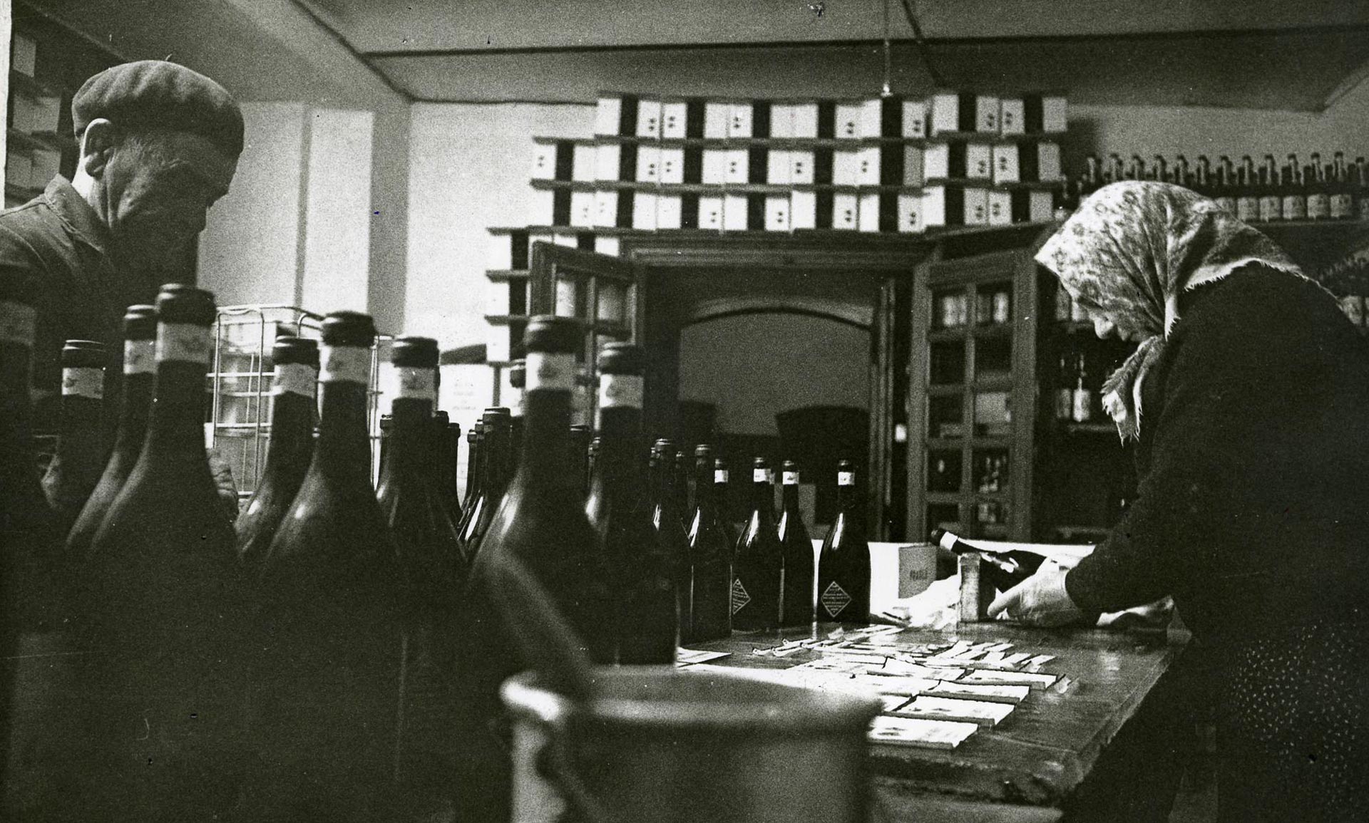 Historical photo depicting the labeling process of wine bottles
